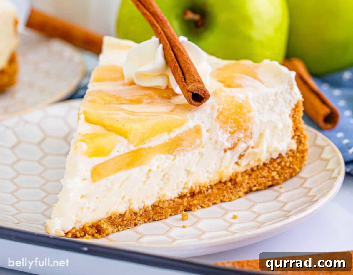 No Bake Apple Pie Cheesecake 5 A pristine slice of no-bake apple cheesecake on a white plate, ready for serving.