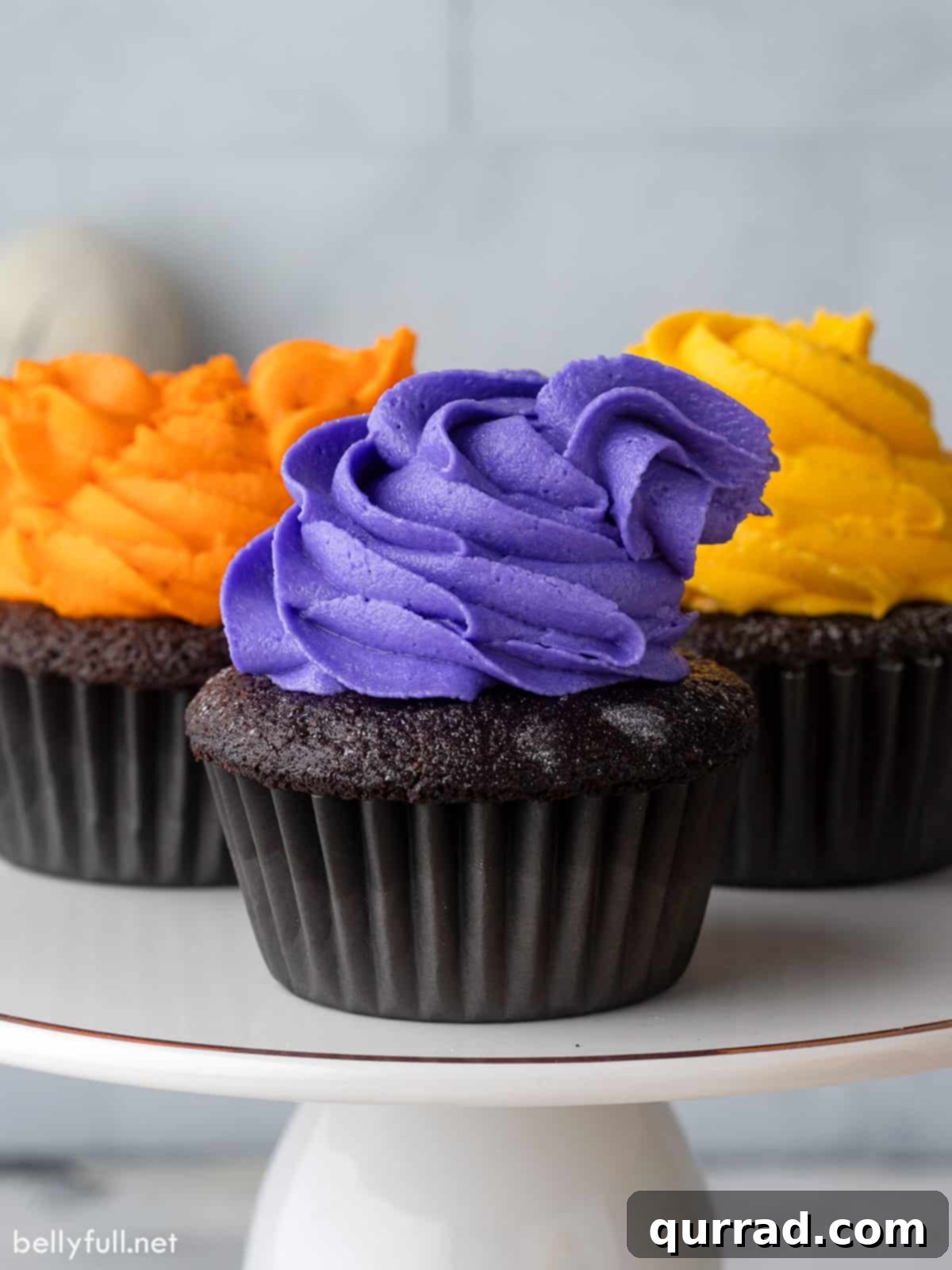 Bewitching Hocus Pocus Cupcakes 2 Front view of 3 Hocus Pocus cupcakes, adorned with colorful buttercream frosting and edible glitter, evoking the magic of Halloween and the Sanderson sisters.