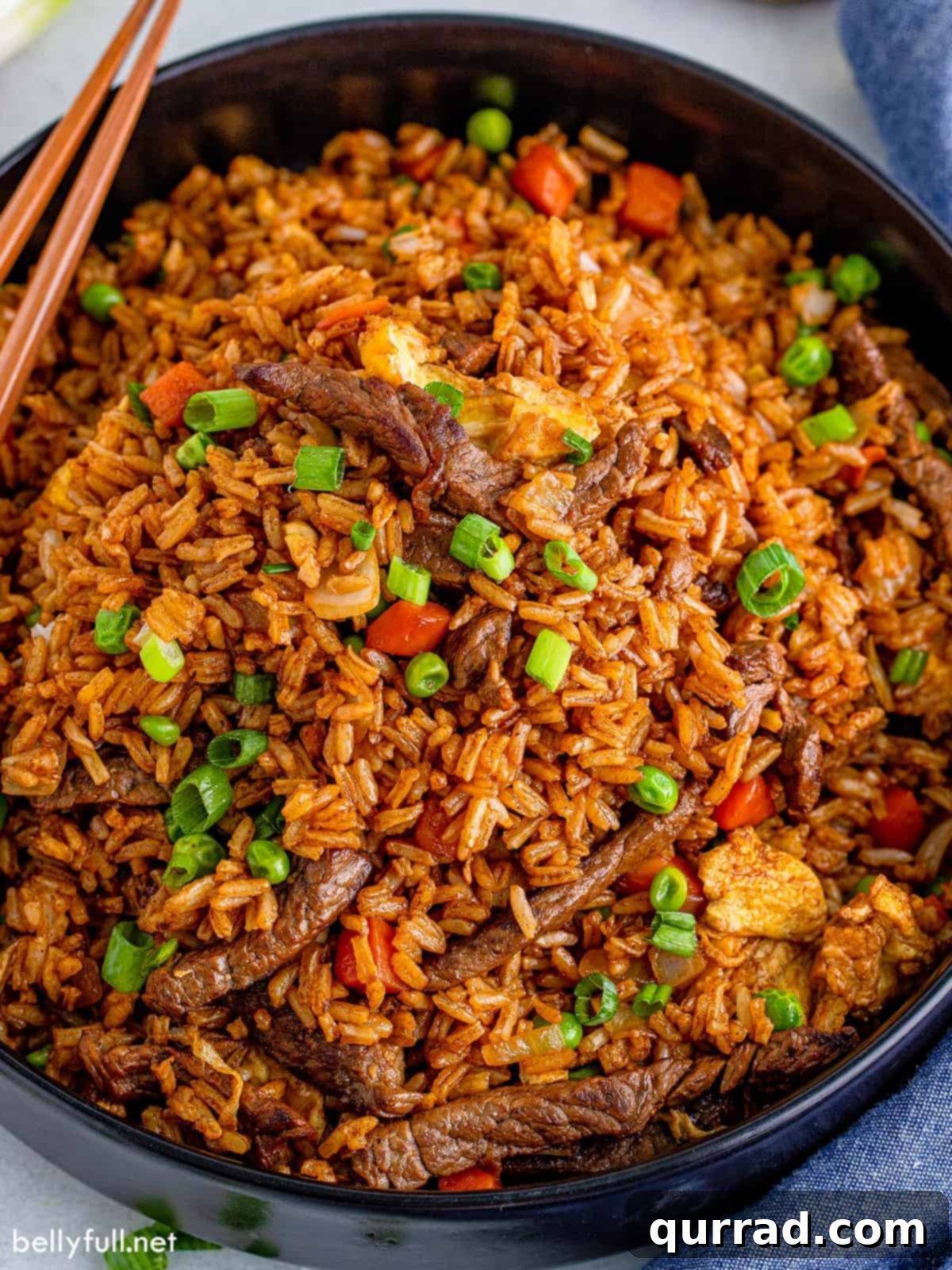 Savory Beef Fried Rice 2 Delicious Beef Fried Rice in a black serving bowl with chopsticks, ready to be enjoyed.