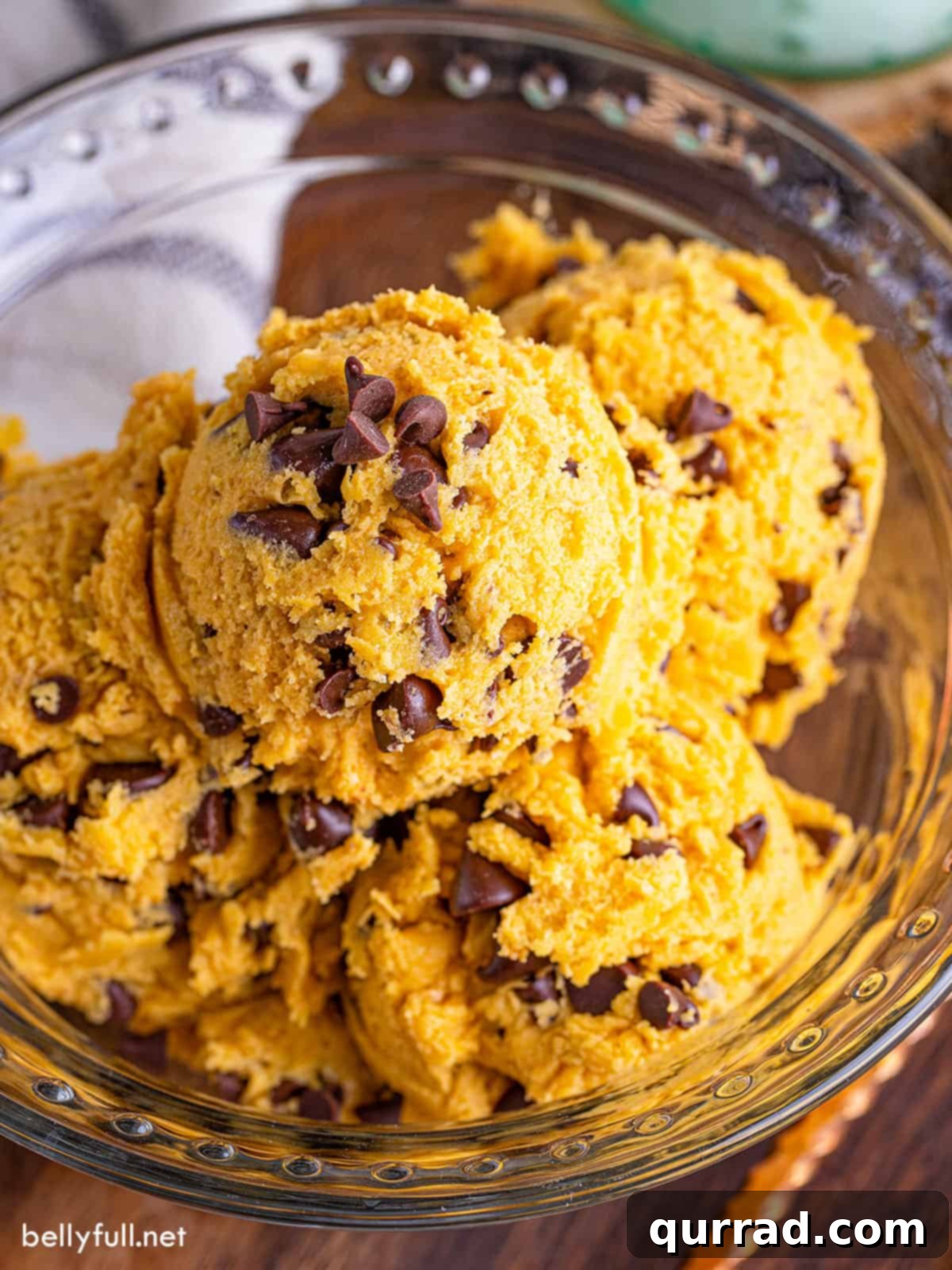 A bowl of scoops of pumpkin edible cookie dough, garnished with a sprinkle of cinnamon