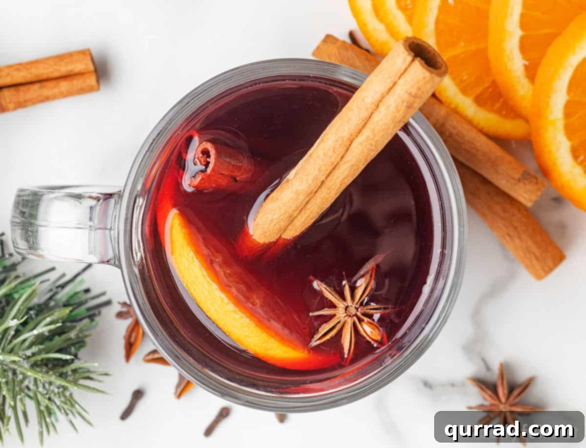Spiced Winter Warmth 8 An overhead view of a beautifully prepared glass of mulled wine, garnished with a cinnamon stick, an orange slice, and a star anise pod.