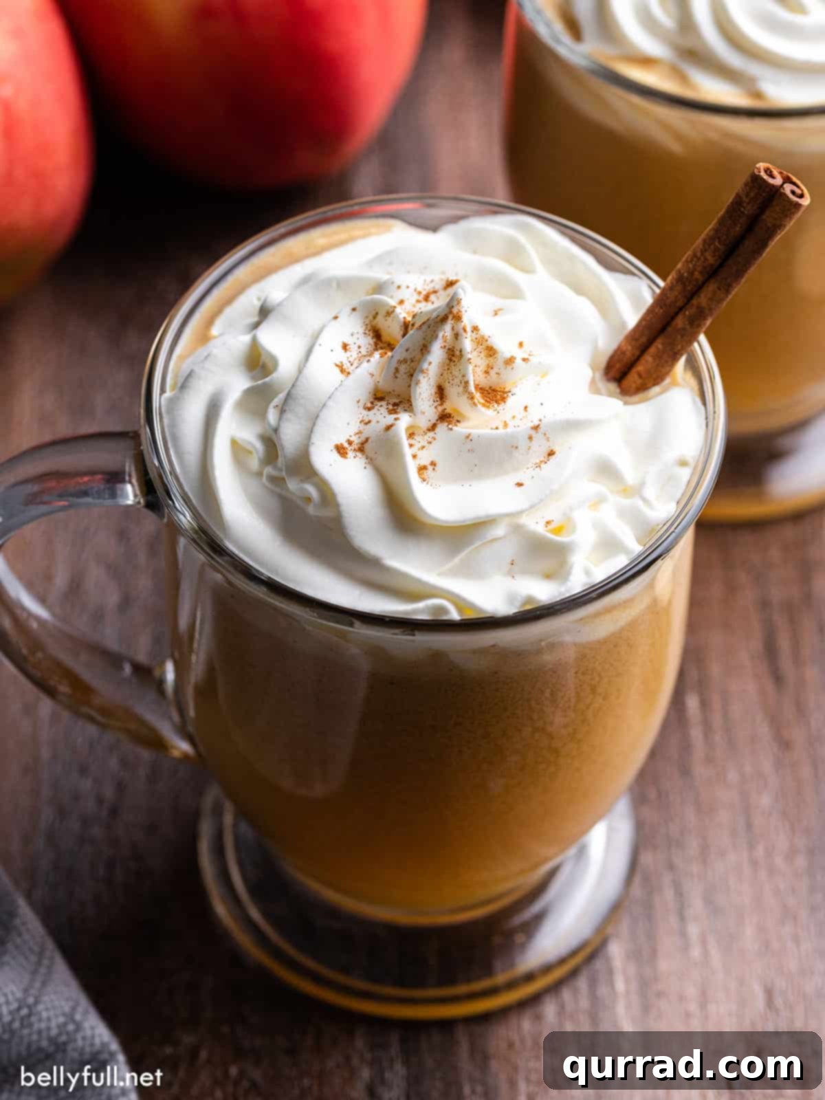 Fireside Golden Buttered Rum 4 A close-up overhead view of a single mug of hot buttered rum, showcasing its creamy texture, topped with whipped cream and a cinnamon stick, ready to be enjoyed.