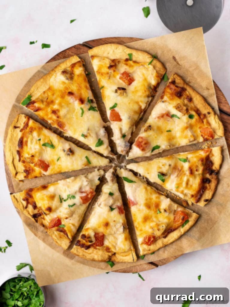 Creamy Chicken Alfredo Pizza 3 Overhead view of a large Chicken Alfredo Pizza sliced into eight pieces