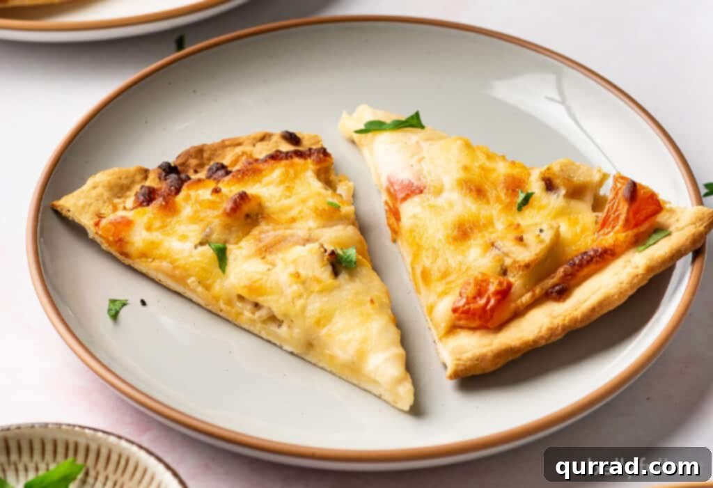 Creamy Chicken Alfredo Pizza 5 Two slices of Chicken Alfredo Pizza on a white plate, garnished with parsley