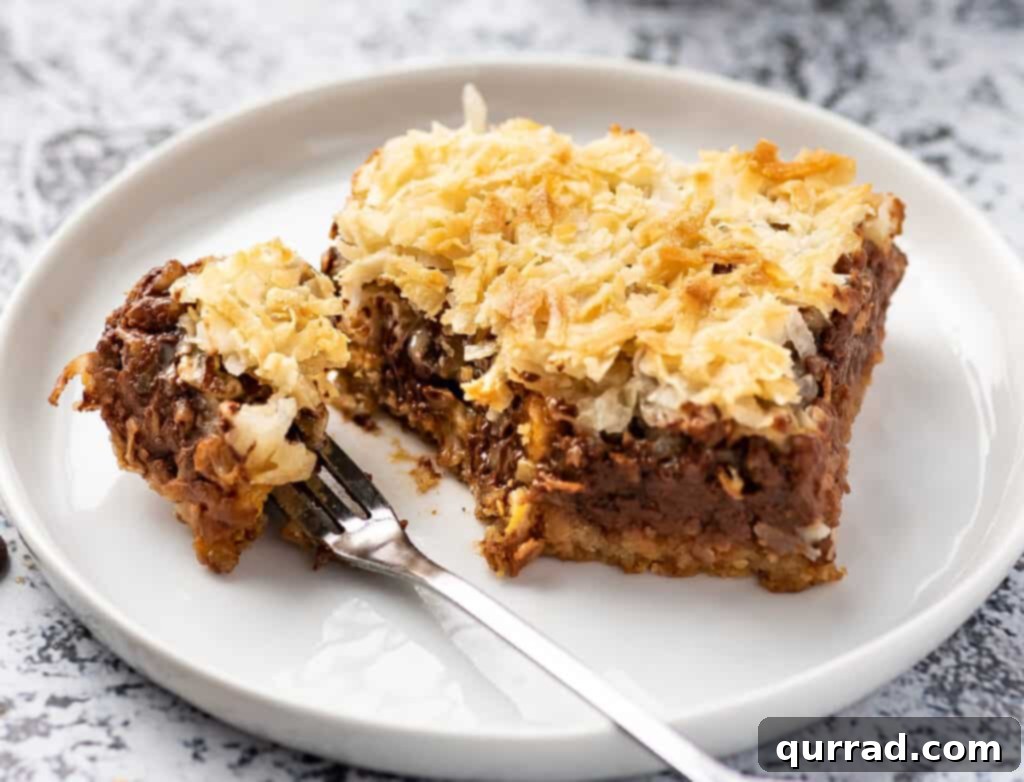 Magic Bars 5 7 layer magic bar on plate with bite taken