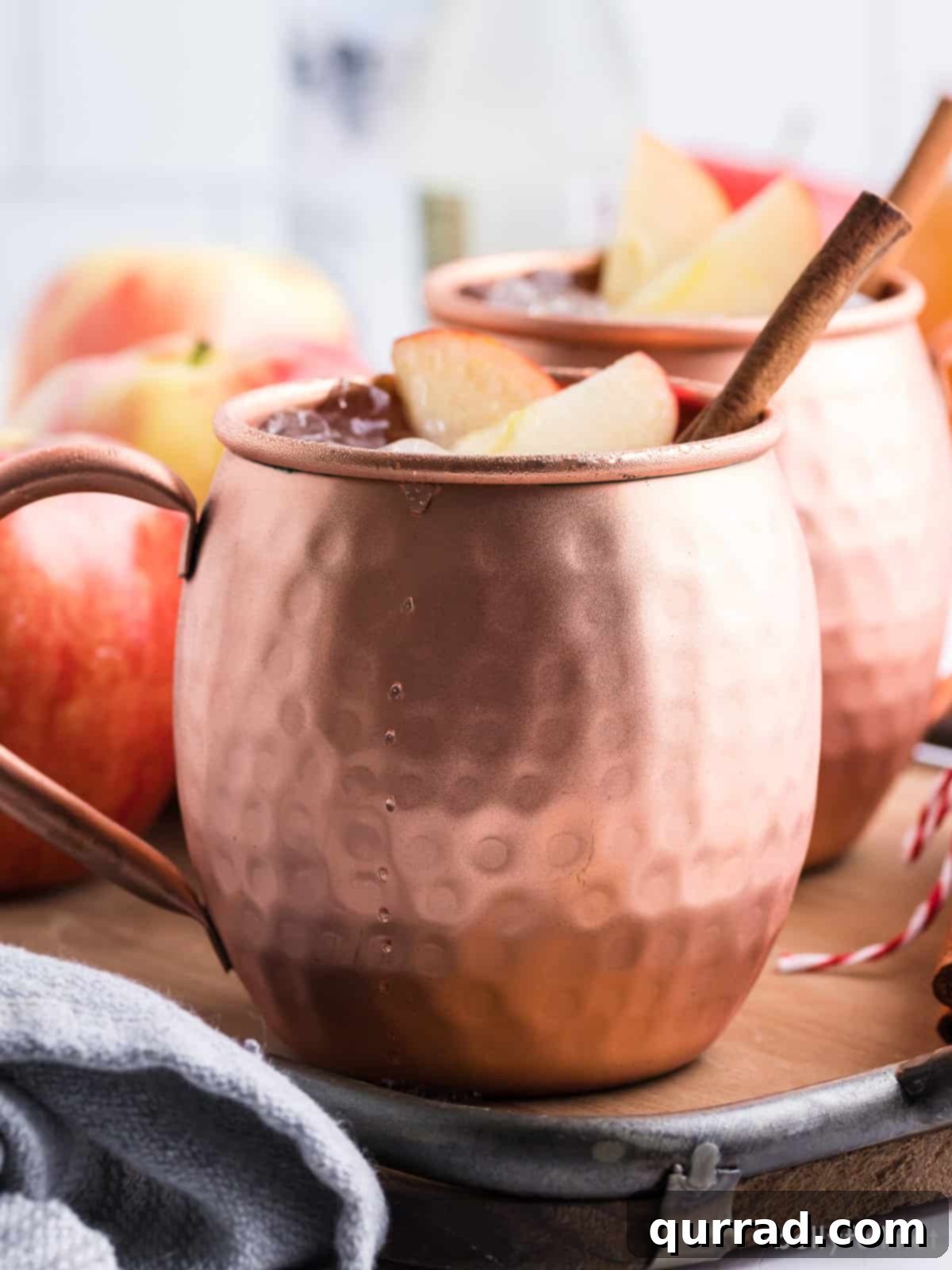 Crisp Apple Mule 3 A glistening Apple Cider Moscow Mule nestled in a classic copper mug, emphasizing its inviting autumn aesthetic.