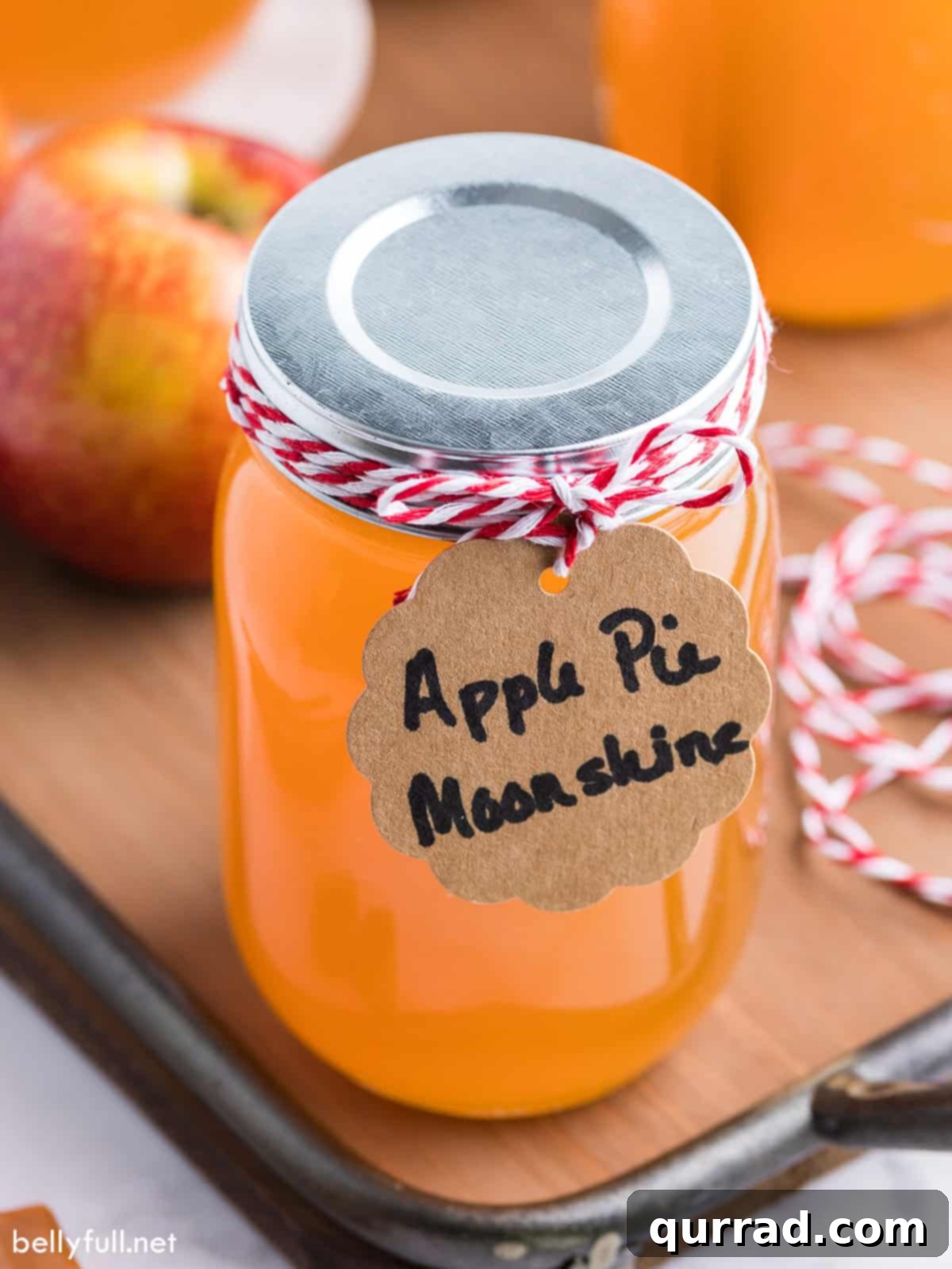A mason jar of apple pie moonshine with a ribbon for gift-giving