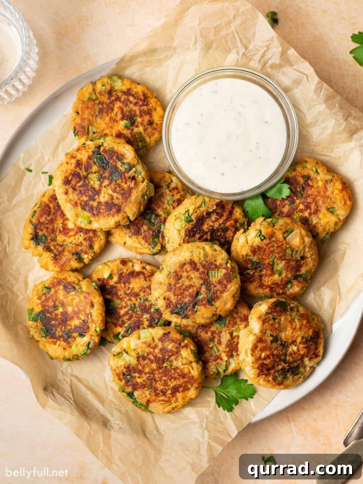Savory Salmon Cakes 4 Overhead view of a plate of salmon cakes with tzatziki sauce