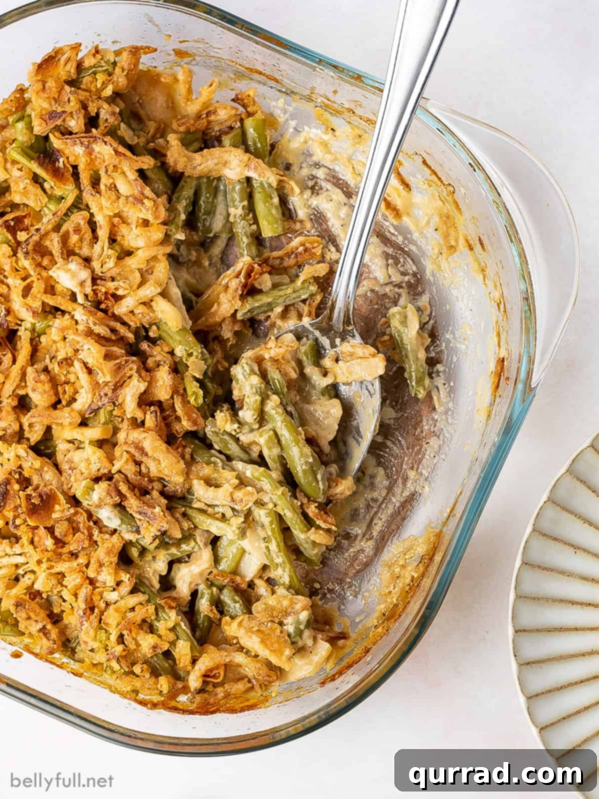 Comforting Green Bean Bake 5 A baking dish of green bean casserole with a serving missing, showcasing its appeal.