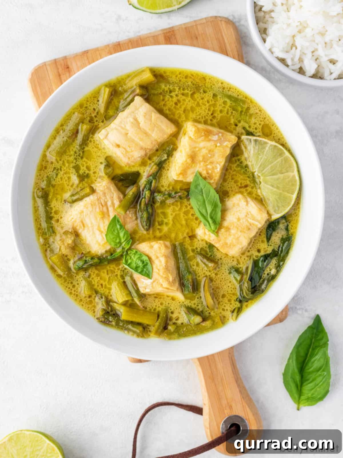Emerald Green Thai Curry 3 An overhead shot showcasing a beautiful bowl of Thai green curry, highlighting the vibrant green sauce and tender fish pieces.