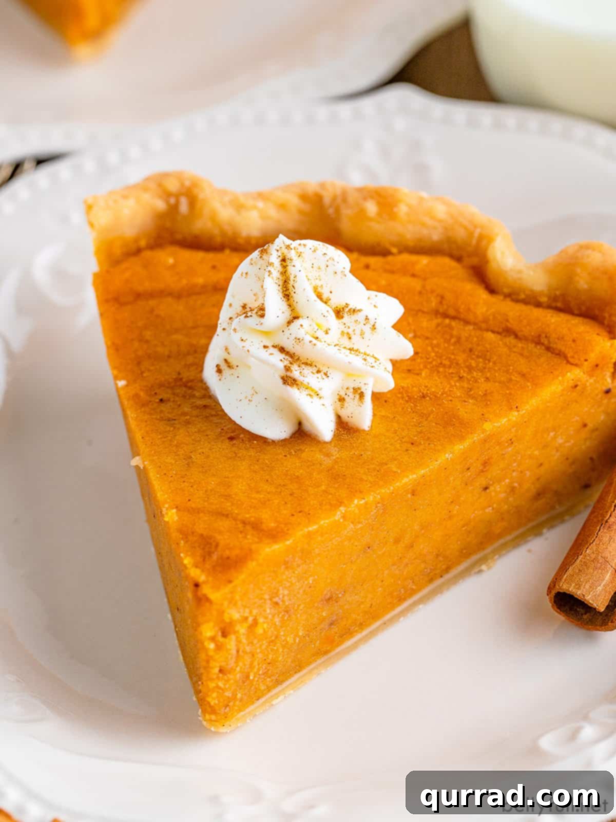 A slice of homemade sweet potato pie with a dollop of whipped cream