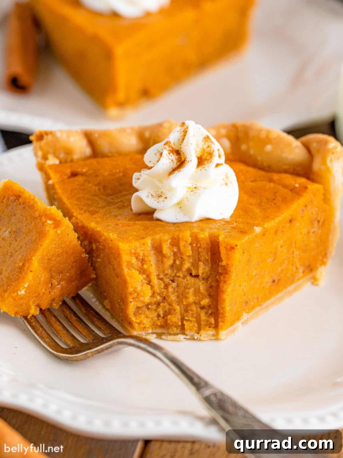 A slice of homemade sweet potato pie with one bite on a fork
