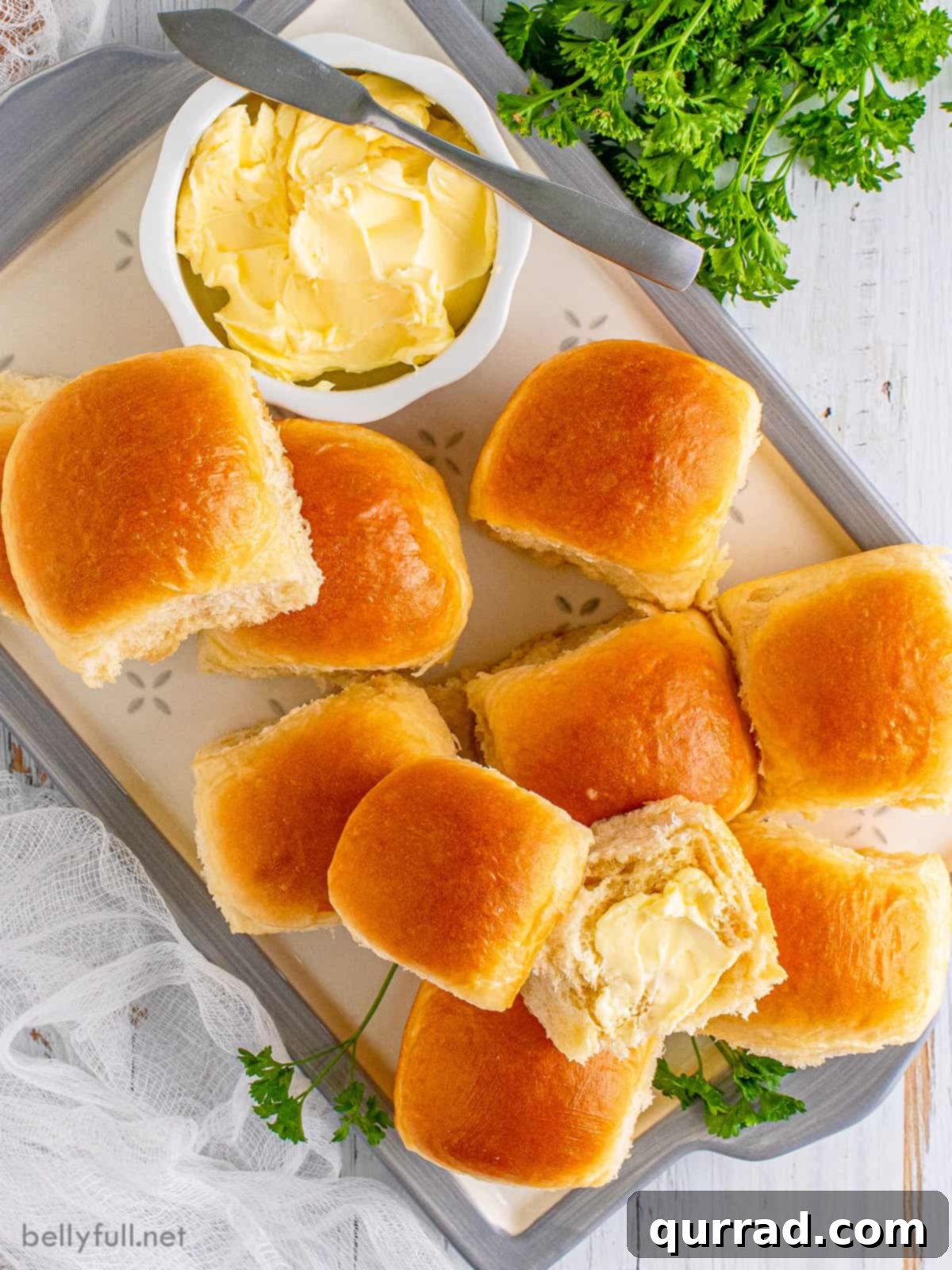 Pillowy Dinner Rolls 5 Overhead view of homemade dinner rolls on a serve platter with butter, ready to be enjoyed