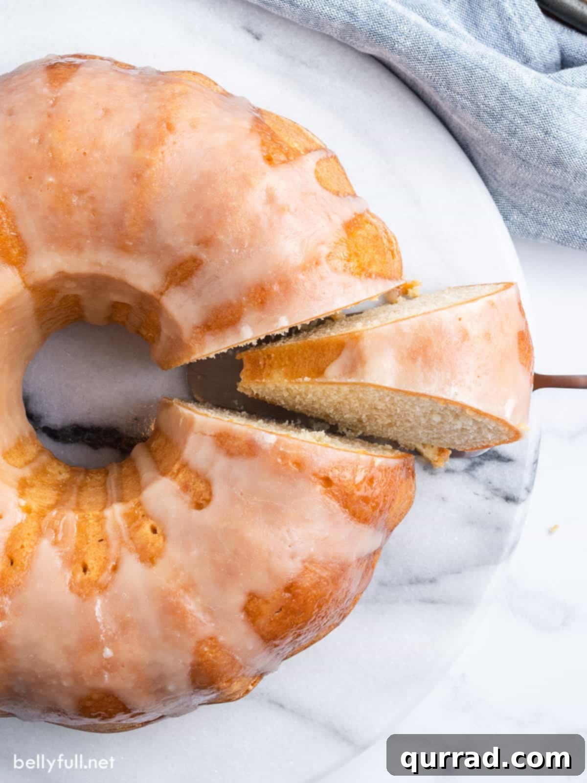 Overhead view of a golden brown Kentucky butter cake with one slice neatly cut and placed next to it, revealing its dense, moist interior
