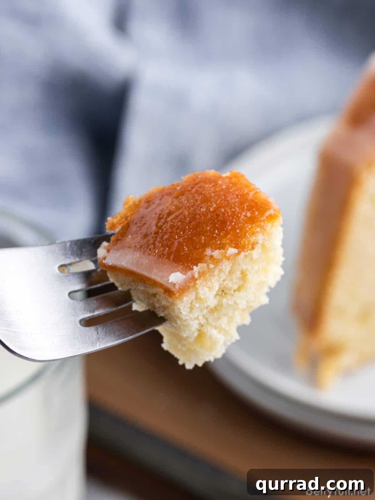 A fork holding a perfect bite of Kentucky butter cake, showing its moist texture and golden glaze