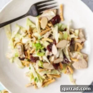 Leftover turkey salad on a white plate with a fork, showing the creamy dressing and crunchy elements