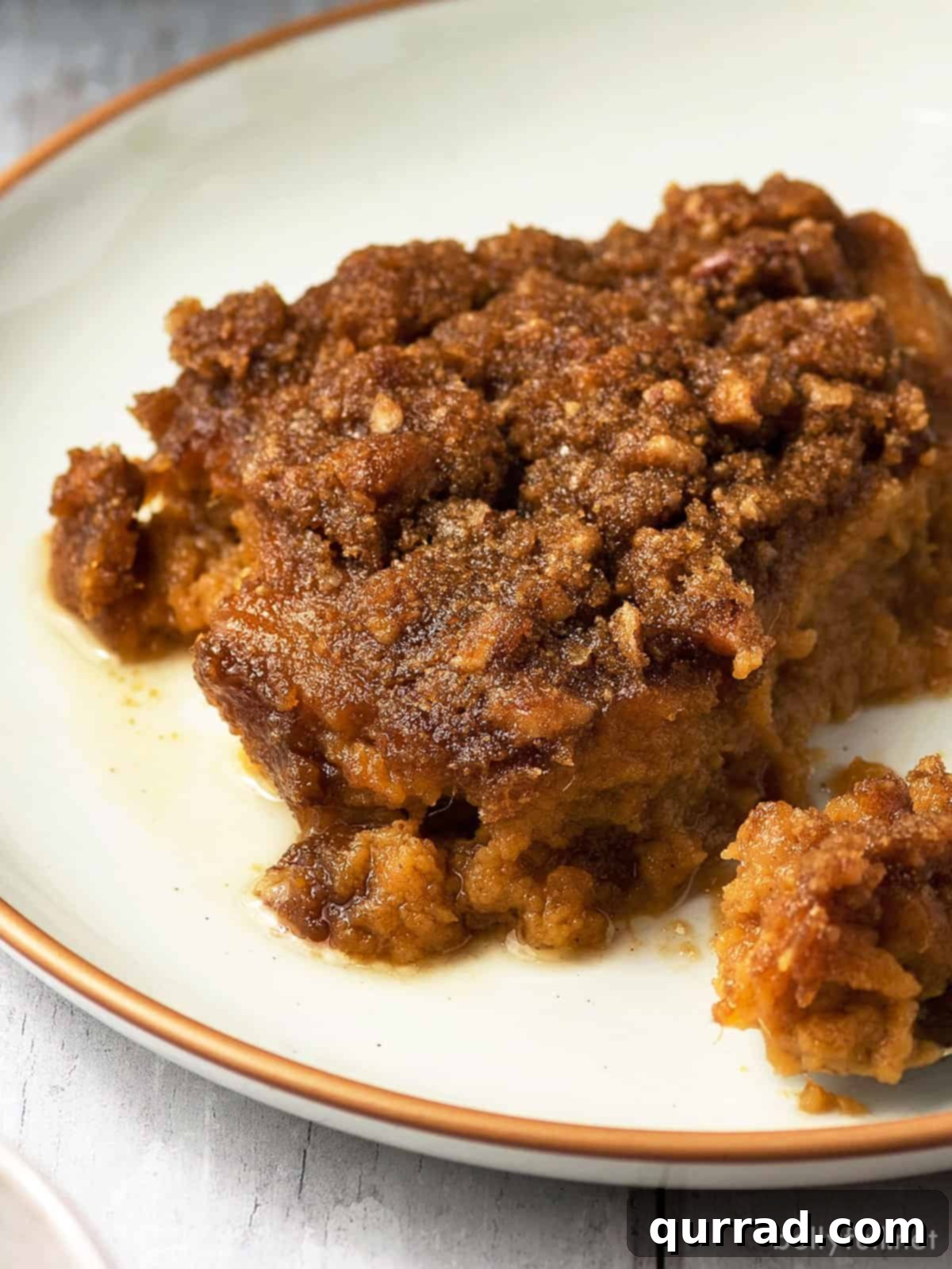 Heavenly Sweet Potato Bake 4 A serving of sweet potato casserole topped with a golden pecan crumble, presented on a white plate.