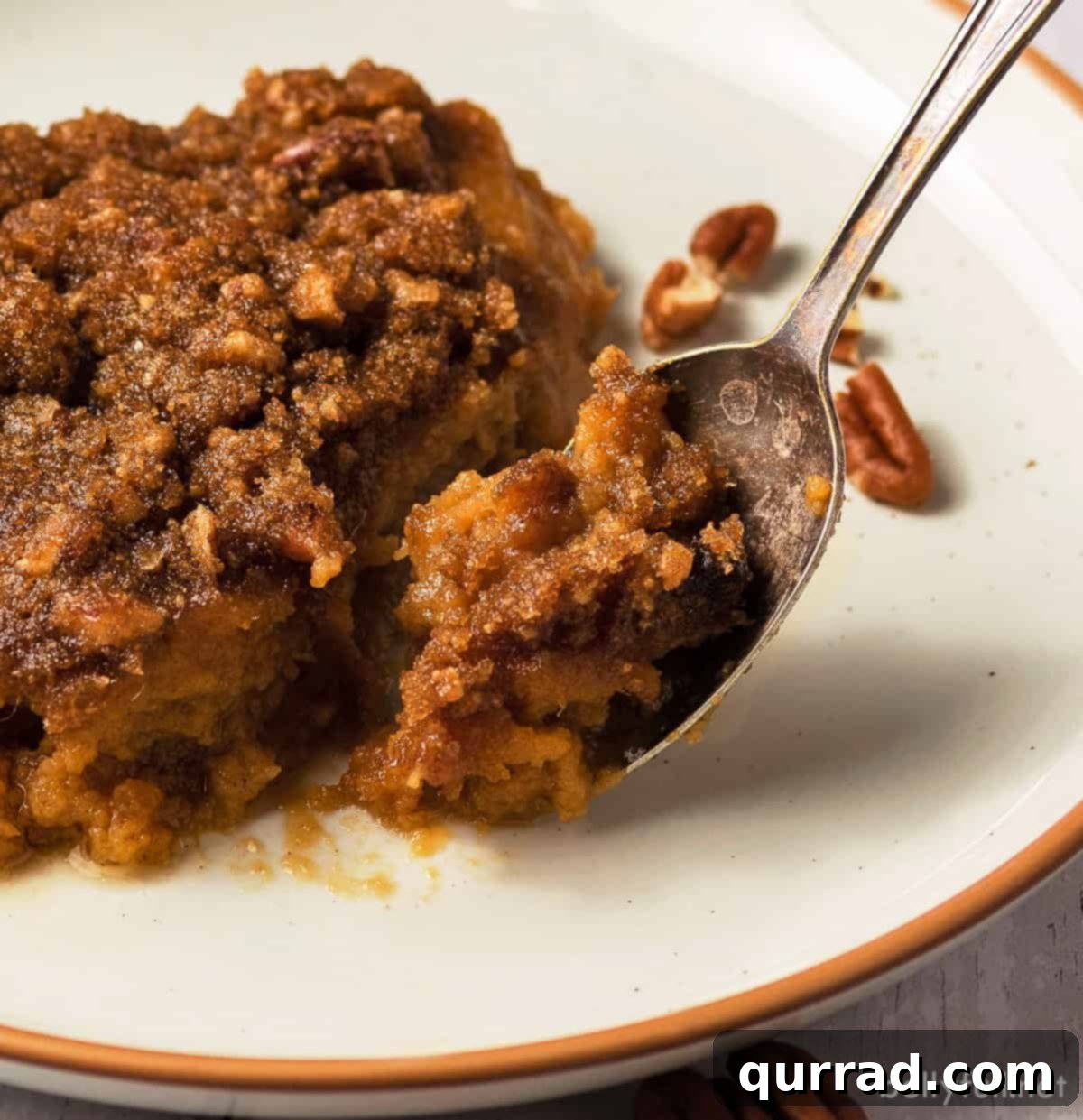 Heavenly Sweet Potato Bake 5 A close-up shot of a single serving of sweet potato casserole on a plate with a serving spoon, highlighting the rich texture.