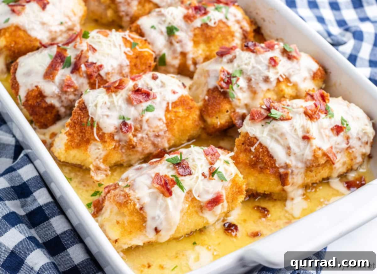 Golden Chicken Ham and Swiss 9 Eight pieces of cooked chicken cordon bleu in a white baking dish, ready for topping.