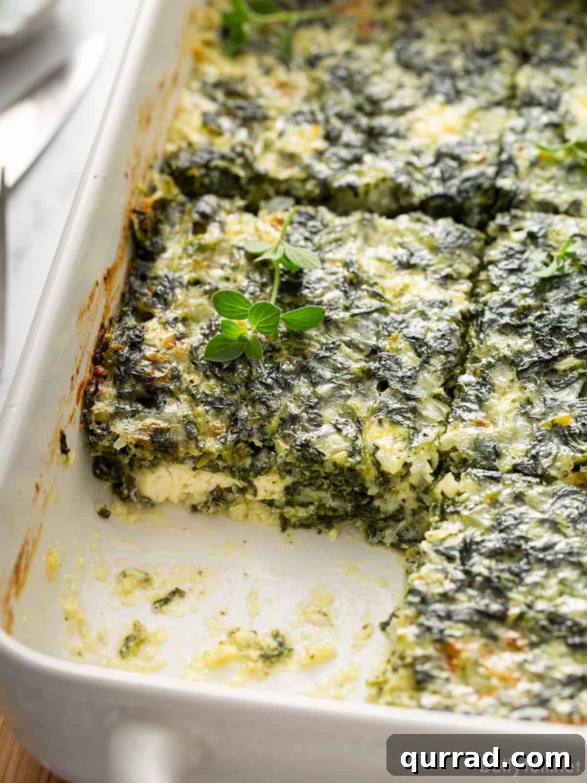 Mediterranean Feta Spinach Bake 5 Baked spinach casserole in a baking dish, perfectly cut into squares, ready for serving.