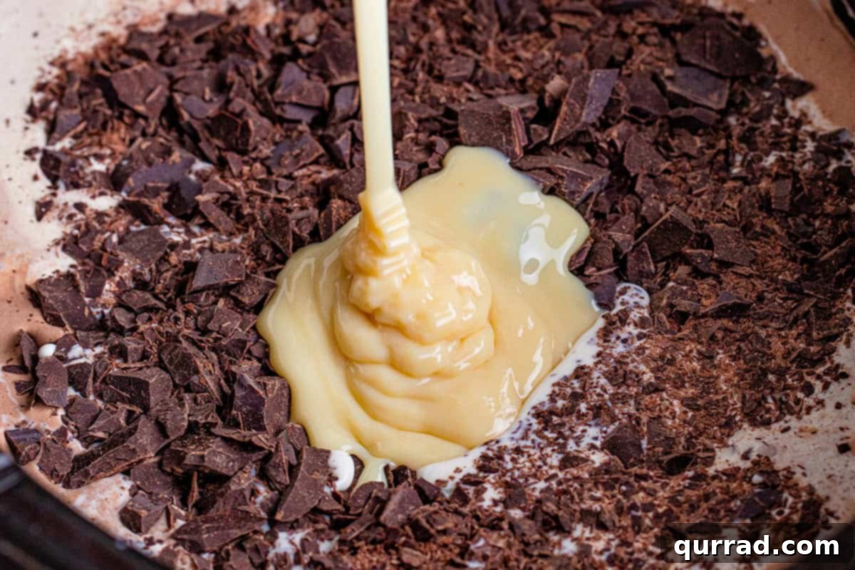 Dreamy Slow Cooker Hot Cocoa 7 sweetened condensed milk being added to milk, cream, and chopped chocolate