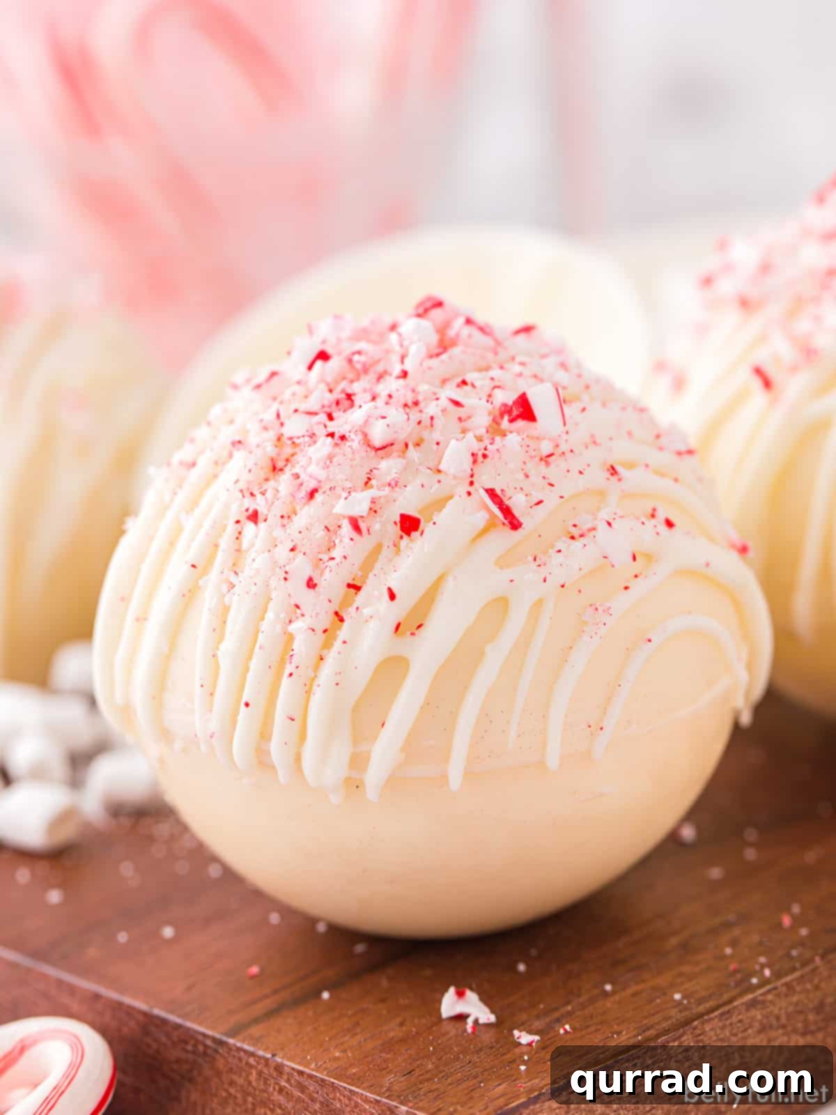 White Hot Cocoa Magic Melts 5 A close-up photograph of a beautifully finished white hot chocolate bomb, elegantly garnished with crushed peppermint pieces, ready for a luxurious treat.