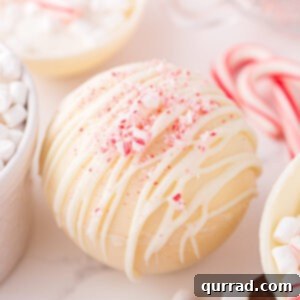 White Hot Cocoa Magic Melts 7 A beautifully crafted peppermint white hot chocolate bomb, showcasing its elegant white shell and festive peppermint garnish.