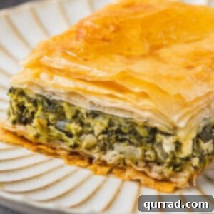 A crisp slice of spanakopita on a plate, ready to be enjoyed.