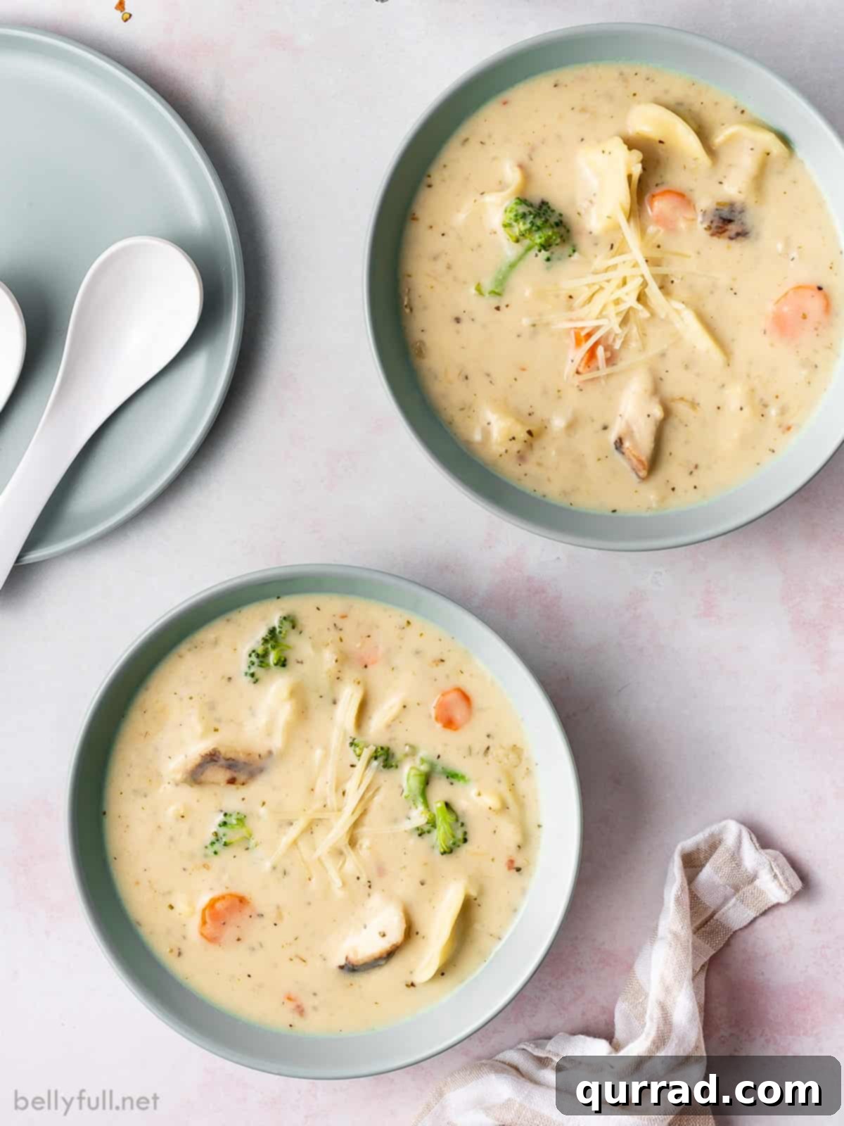 Creamy Parmesan Chicken Tortellini Soup 4 Overhead view of two generous bowls of chicken alfredo tortellini soup, garnished and ready to eat.