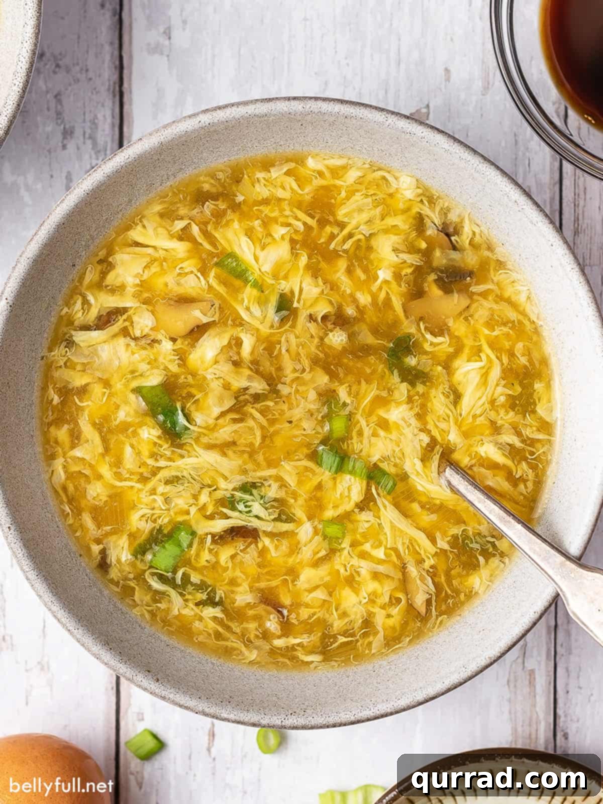 Classic Egg Drop Soup 2 Overhead view of a bowl of homemade egg drop soup, garnished with fresh green onions.