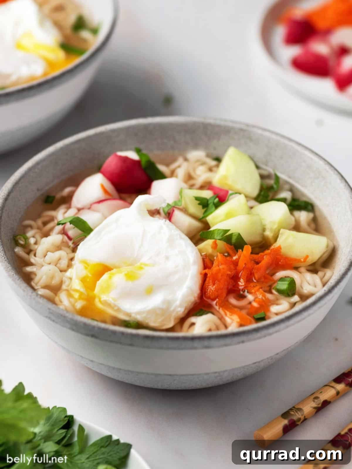 A close-up of Hot and Sour Ramen Soup, beautifully topped with a perfectly poached egg and fresh green garnishes.