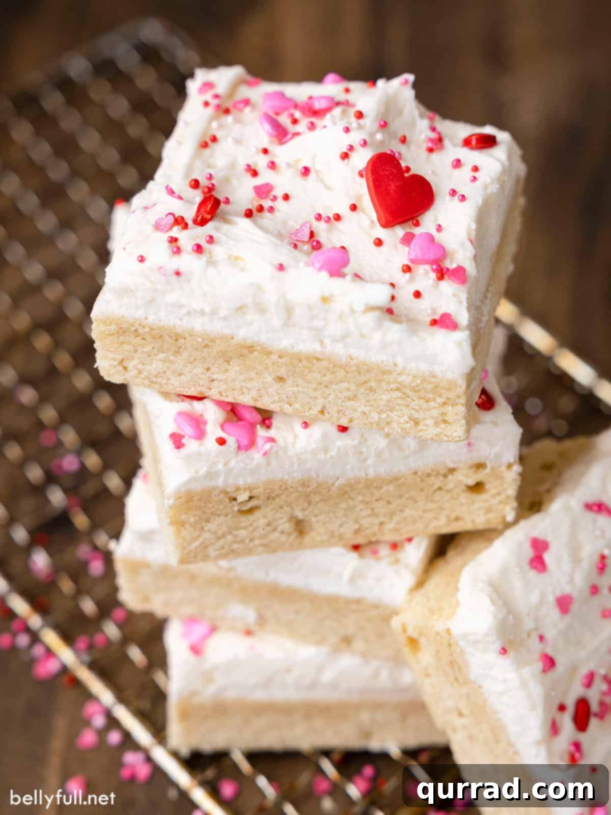 Soft Frosted Sugar Cookie Bars 2 A beautifully arranged stack of frosted sugar cookie bars, showcasing their thick layer of frosting and colorful sprinkles. An ideal dessert for Valentine's Day or any festive occasion.