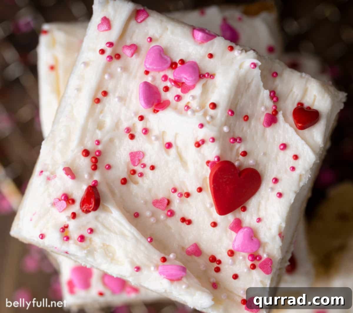 Soft Frosted Sugar Cookie Bars 5 A close-up shot of a single frosted sugar cookie bar adorned with festive Valentine's Day sprinkles, highlighting its perfect texture and vibrant decoration.