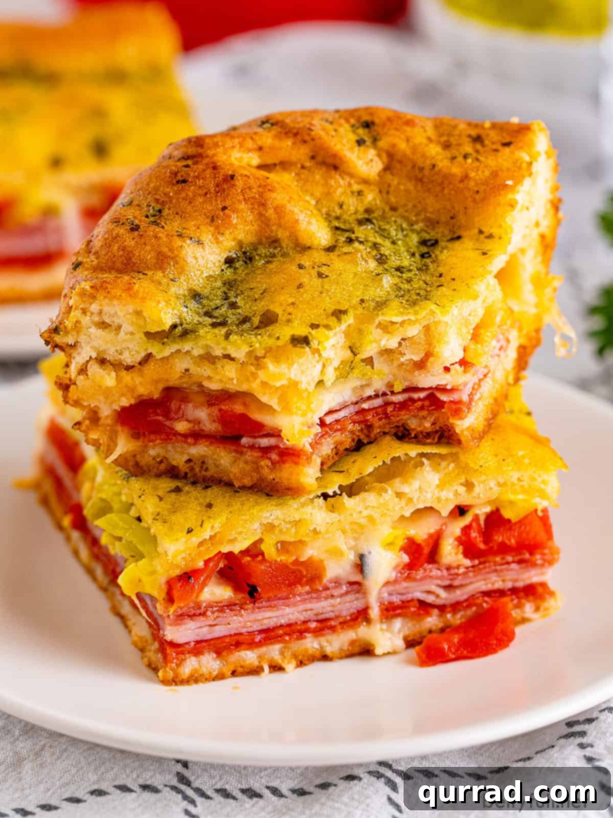 Savory Antipasto Squares 2 Two golden brown Antipasto Squares stacked on each other, showing the cheesy, meaty layers.