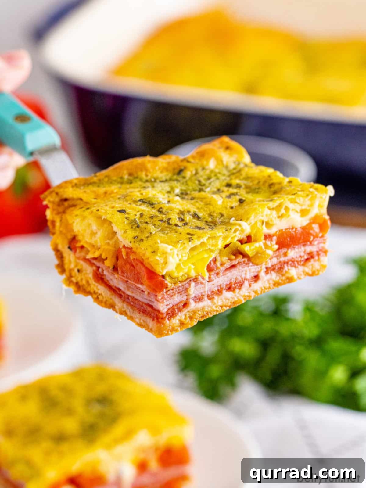 Savory Antipasto Squares 4 A spatula serving a hot Antipasto Square from the baking dish, showing its delicious layers.