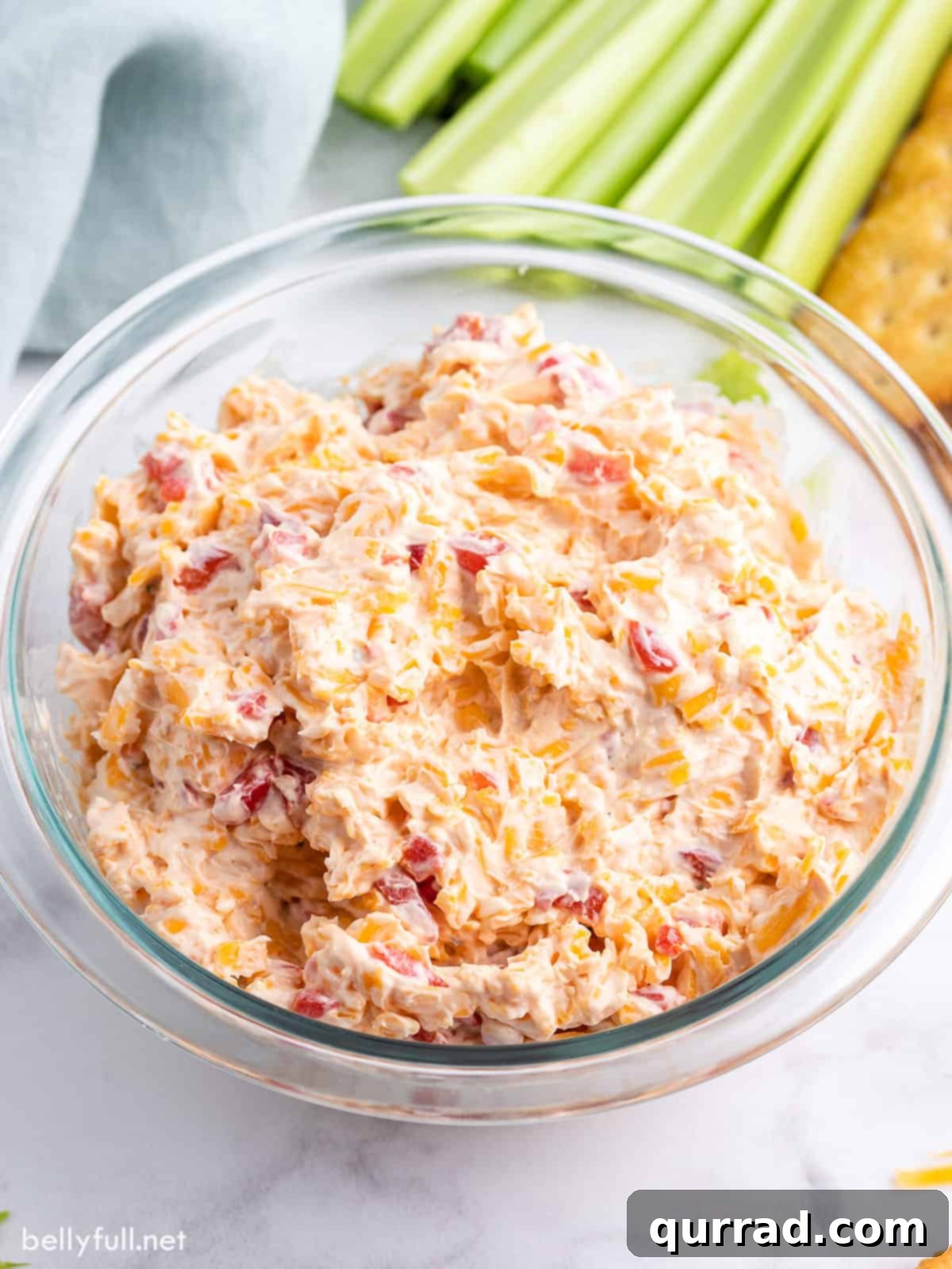 An overhead view of a bowl filled with freshly prepared pimento cheese dip, garnished and ready to be served, highlighting its appealing texture and color.
