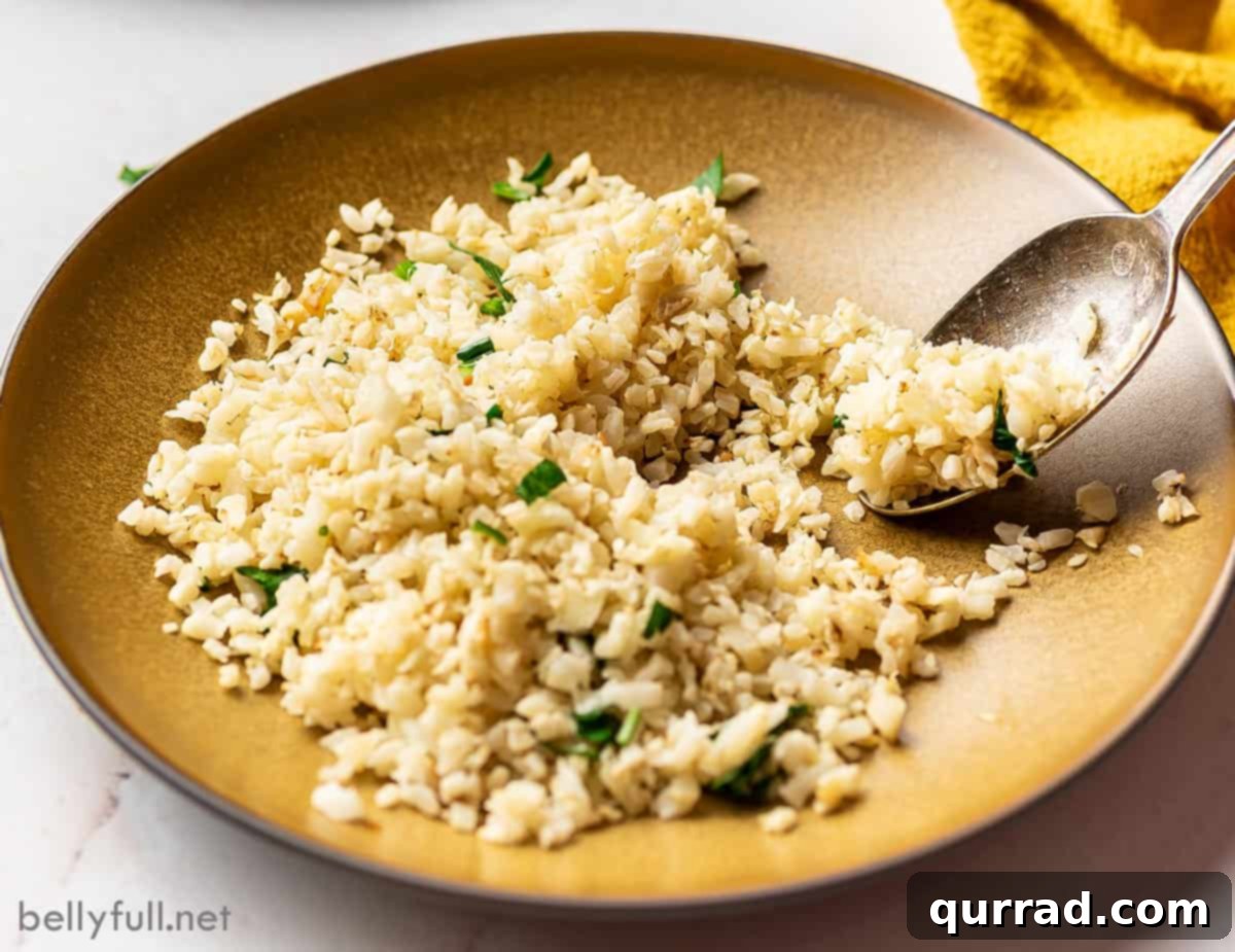 Wholesome Cauliflower Grains 5 Cauliflower rice garnished with fresh herbs in a brown bowl with a spoon.