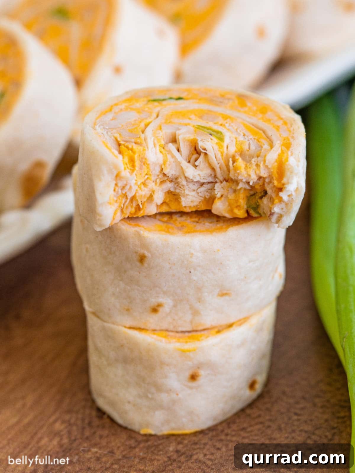 Three buffalo chicken pinwheels, the top one missing a bite