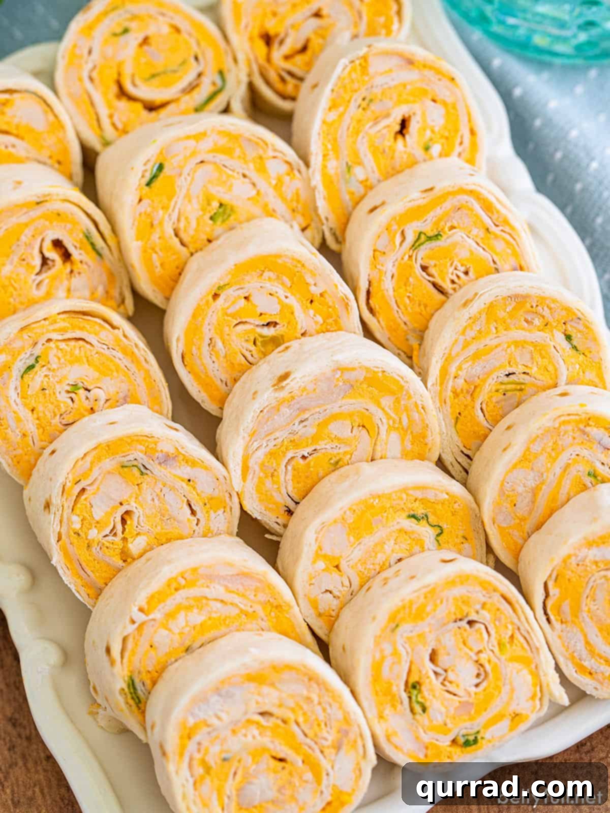 Overhead view of buffalo chicken roll-ups on a white platter