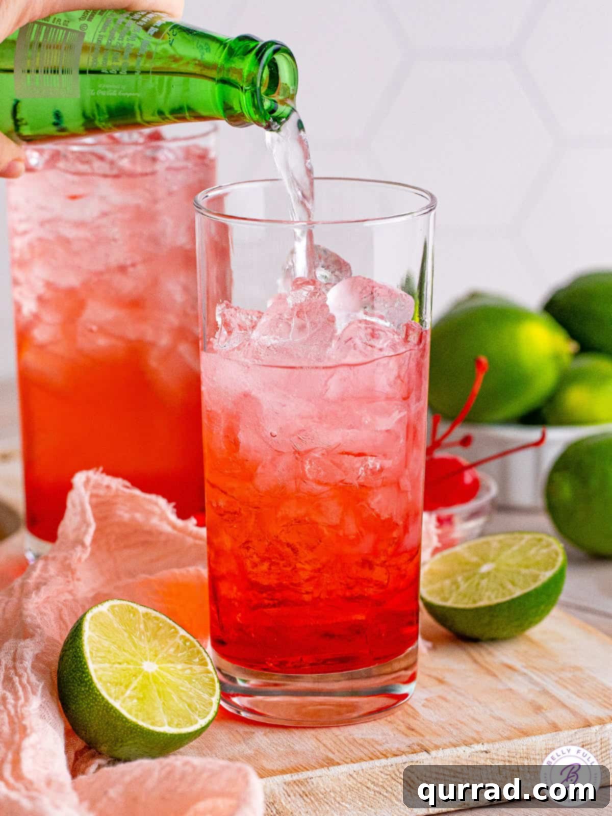 Tipsy Temple 4 Soda being poured into a tall glass filled with ice, cherry juice, and vodka, creating a vibrant Dirty Shirley cocktail