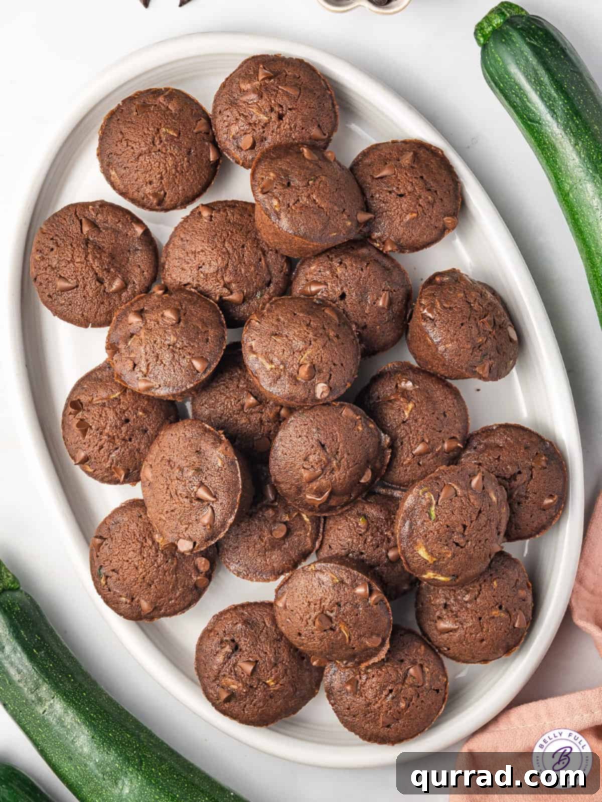 A close-up shot of a plate brimming with freshly baked mini chocolate cakes, each showcasing its moist texture and inviting chocolate chips.