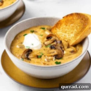 A bowl of Hungarian mushroom soup with a piece of crusty bread
