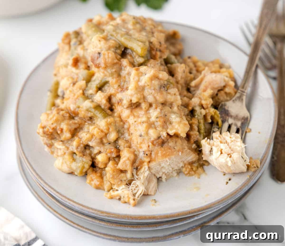 Homestyle Slow Cooker Chicken and Stuffing 10 Close-up angled view of a plate of creamy Crockpot Chicken and Stuffing with green beans