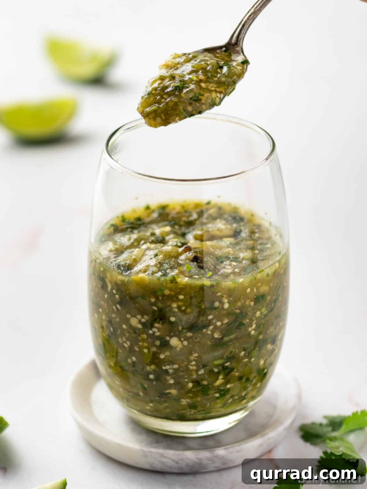 A glass of salsa verde with a spoonful above