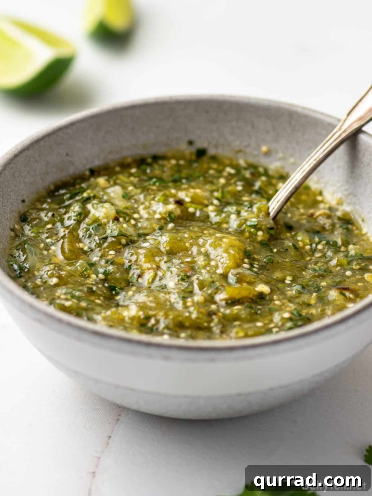 A white bowl of salsa verde with a spoon