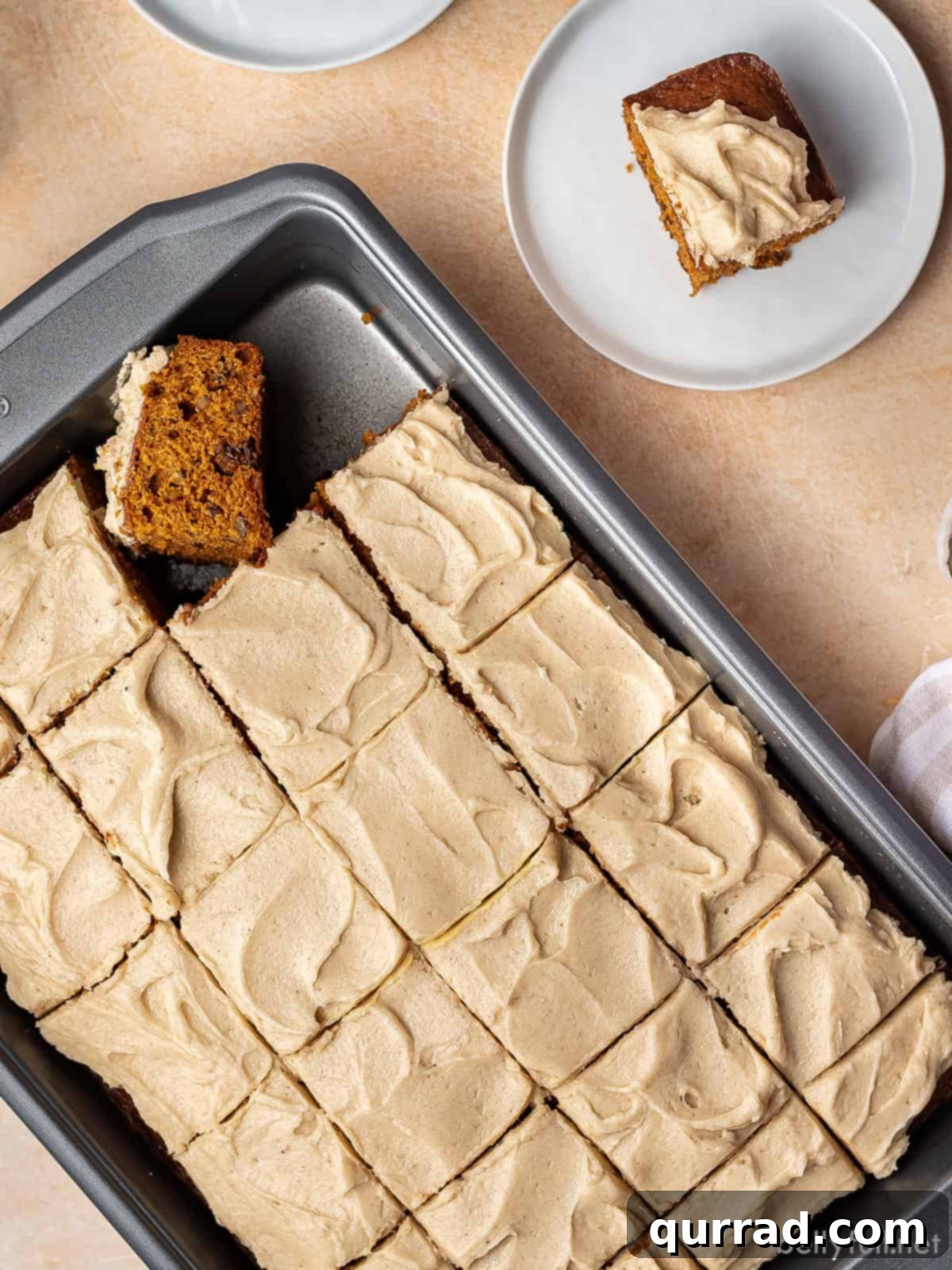 Velvet Tomato Spice Cake 4 A perfectly cut square of frosted spice cake sits on a delicate plate, ready to be enjoyed. The rich brown sugar frosting covers the moist, spiced cake, inviting a delicious bite.