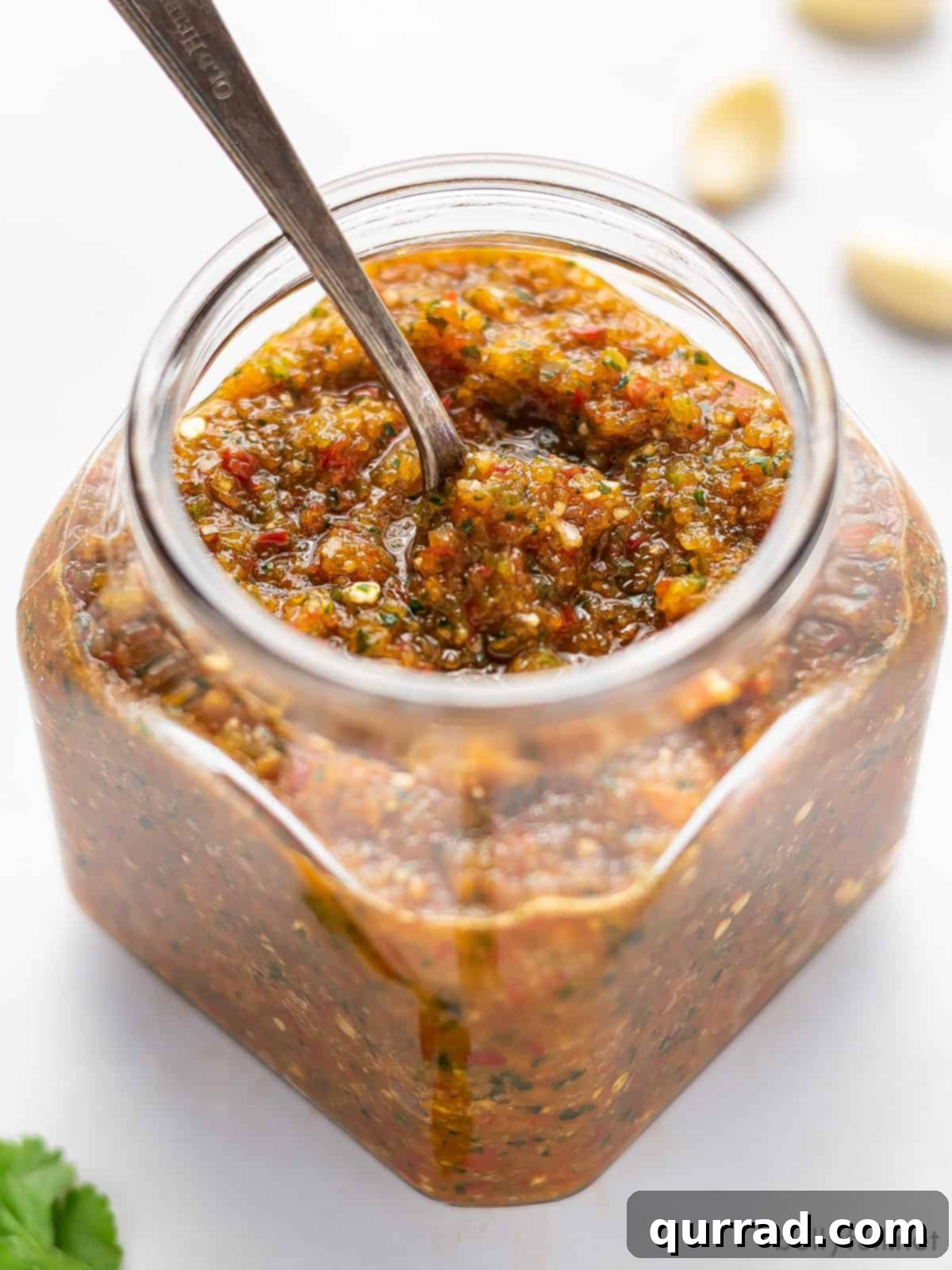 The Flavorful Foundation 3 Overhead shot of a jar of homemade Puerto Rican Sofrito with a spoon dipped in, showcasing its vibrant green color and thick texture.