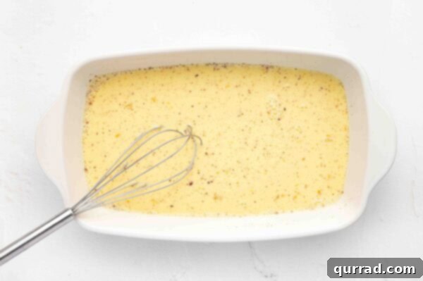 Decadent Challah French Toast 5 Egg custard and whisk in a casserole dish, illustrating the whisking process.