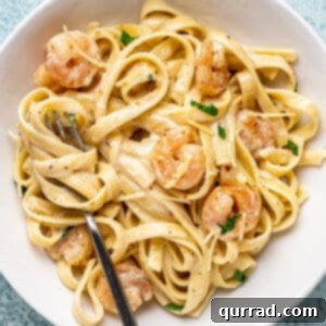 overhead shrimp alfredo in white bowl with fork
