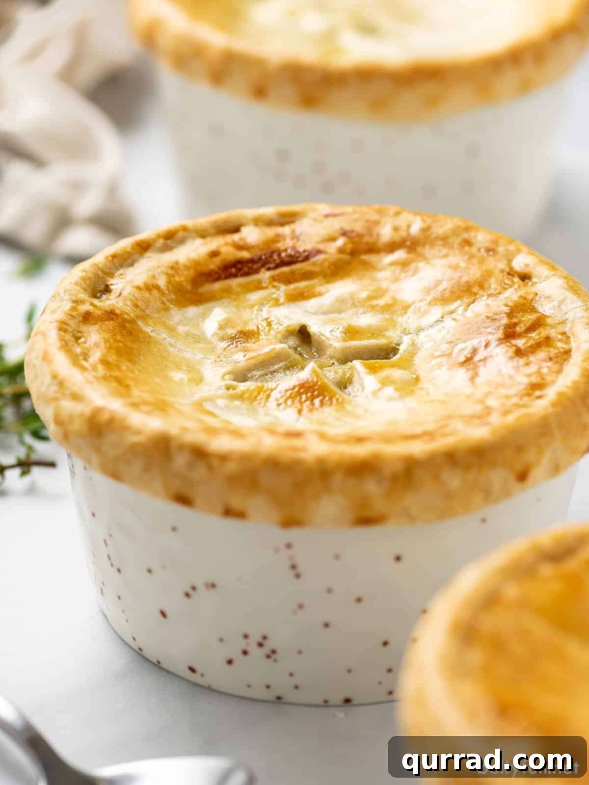 Angled view of a single homemade chicken pot pie in a ramekin, ready to be served